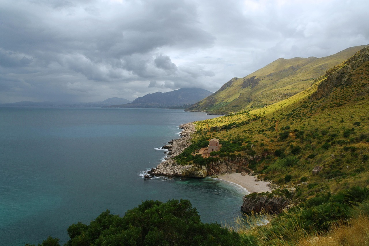 Paesaggio mozzafiato della Sardegna, con spiagge e montagne che evocano un set cinematografico.