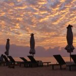 Spiaggia paradisiaca di Bali con palme e mare cristallino, simbolo di una vacanza da sogno.