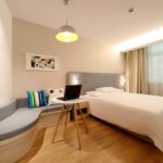 Immagine di una persona che prenota un hotel online su un laptop, con grafico di risparmio in evidenza.