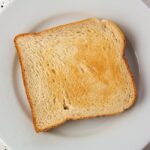 Fette biscottate con etichetta di marca controversa, simbolo di potenziali danni per salute.