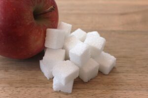 Frittelle di mele alte e soffici servite su un piatto, con una spolverata di zucchero a velo.