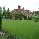 Prato inglese verde lussureggiante con evidenti segni di usura e malattie erbose.